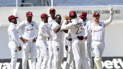 Kemar Roach (4L) and teammates celebrate the dismissal of Abid Ali. AFP