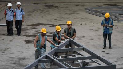 Chinese workers assemble a steel structure at the new Beijing Daxing international airport. Steel prices have been resilient despite the yuan being Asia's worst-performing currency. AFP