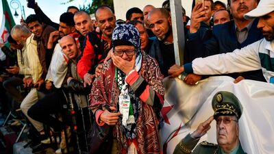 A woman mourns as she joins other people outside the "Palais du Peuple." AFP