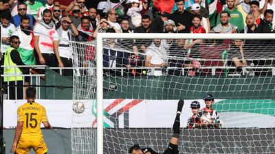 Palestine's goalkeeper Rami Hamadi fails to catch the ball as Australia scores. AFP