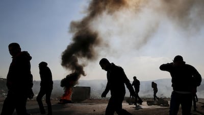 Palestinian protesters react to tear gas fired by Israeli troops during clashes in the West Bank village of Silwad, near Ramallah. Ammar Awad / Reuters