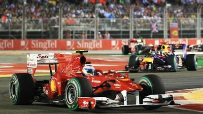 Fernando Alonso of Spain and Ferrari leads from Sebastian Vettel of Germany and Red Bull Racing and the rest of the field during the Singapore Formula One Grand Prix.
