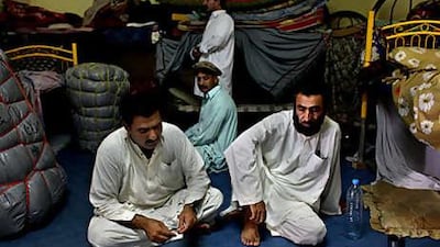 Drivers Gul Rahood, left, and Gul Mohammed, right, share a room in a dilapidated villa near Mohammed bin Zayed City, an enclave on the outskirts of Abu Dhabi. Most in their group are out of work.