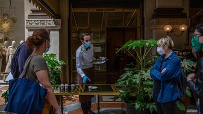 A worker serves coffees for takeaway to costumers in Milan. Bloomberg