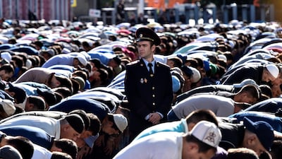 A police officer among Muslims at Moscow Cathedral Mosque at Eid Al Fitr prayers. AFP