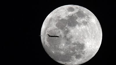 An aircraft passes across a supermoon viewed in Georgia in the US in 2018. A blue supermoon will be visible in the UAE on August 19. Photo: USA Today Sports