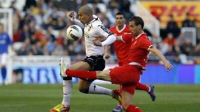 Valencia's Sofiane Feghouli, left, vies for the ball from Sevilla's Fernando Navarro.