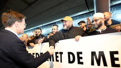 Dutch Prime Minister Mark Rutte shakes hands with members of a Muslim community during a silent march in Utrecht in honour of the people wounded or killed in an attack on a tram on Monday. Reuters
