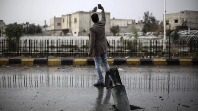 A Syrian takes a selfie by an unexploded bomb buried in the tarmac of a road in the rebel-held area of Douma, Syria. Mohammed Badra / EPA