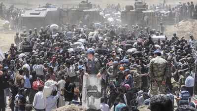 Syrian refugees wait for transportation after crossing into Turkey from the Syrian town of Tal Abyad, in Sanliurfa province, on June 10. AFP Photo