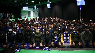 People pray at Stamford Bridge stadium. Reuters