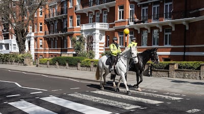 Two mounted police officers ride their horses across the famous Abbey Road crossing as a Highways Maintenance team take advantage of the Covid-19 lockdown to refresh the markings. Getty Images