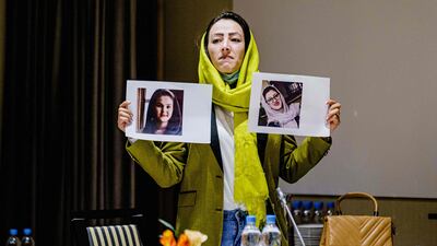 Delegate Heda Khamoush holds up photos of women’s rights activists detained in Afghanistan in Oslo, Norway. AFP