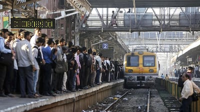 Commuters wait on a crowded railway platform as a train enters a suburban station in Mumbai. Danish Siddiqui / Reuters