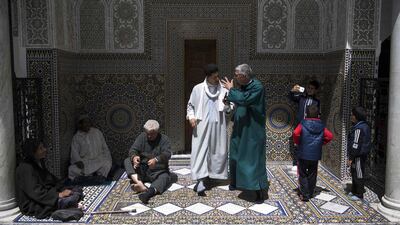 Men gather at the Moulay Idriss II mausoleum in the 9th century walled medina in the ancient Moroccan city of Fez on April 11, 2019. AFP