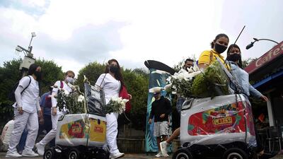 People look at robots distributing flowers during a flower fair in Medellin, Colombia. EPA