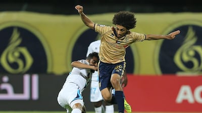 Khalid Hussain Hassan Jama, right, of Dubai eludes a Baniyas defender's challenge during their League Cup match at Dubai Club Stadium on March 2, 2014. Al Ittihad