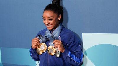 Simone Biles holds up her medals won at the Paris Olympics. AP