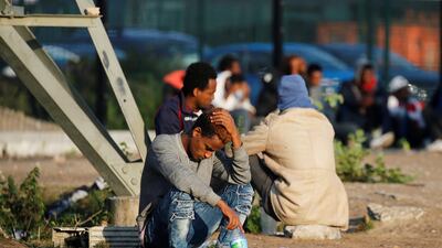Migrants wait for a food distribution near the former 'jungle' in Calais, France, August 23, 2017. Reuters