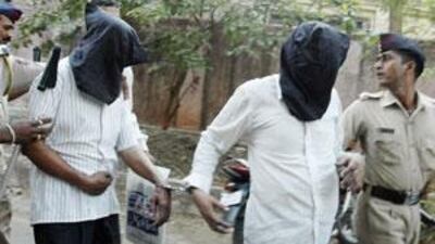 Hasmukhbhai Rathod, 54,a practitioner of the ancient Indian art of the occult, left, and a 49-year-old Indian businessman who is alleged to have raped his daughter for more than eight years are escorted by police officers outside a court in Mumbai.