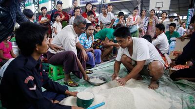 Residents gather to collect food aid at a temporary evacuation center in Hpa-An Township, Kayin State, Myanmar. EPA / LYNN BO BO