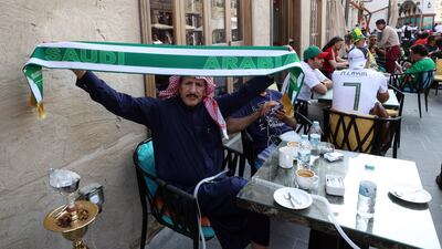 A fan of Saudi Arabia flies his team's colours at Souq Waqif in Doha. EPA