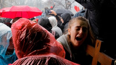 A young woman with a crucifix cries as police use a water cannon to disperse protesters demonstrating against the coronavirus lockdown measures imposed by the German government, close to the Reichstag building in Berlin. AFP
