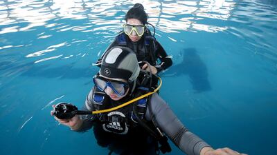 Swimming coach Elaf checks a scuba diving student's oxygen supply. Reuters