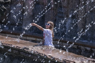 A girl cools off at a fountain near the Kremlin in Moscow, where early summer temperatures reached 32°C. EPA