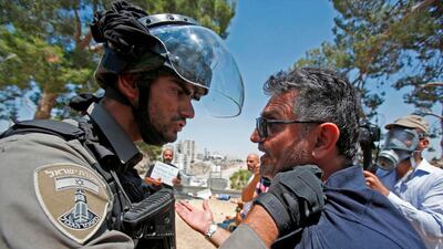 An Israeli border police confronts a Palestinian protester following clashes after the Friday prayers at the site of demolished buildings in the West Bank. AFP