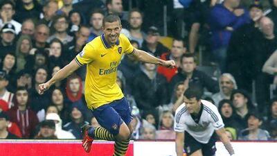 Arsenal's Lukas Podolski, left, celebrates his first goal against Fulham at Craven Cottage. Sang Tan / AP Photo