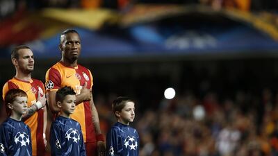 Didier Drogba standing next to Wesley Sneijder during the national anthems before Tuesday's match. Adrian Dennis / AFP / March 18, 2014