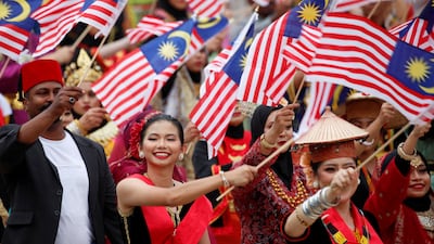 Performers with Malaysia flags celebrate National Day at Putrajaya last month. Malaysia's is a cosmopolitan society. Reuters