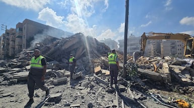 Lebanese civil defence workers search the rubble of a building hit by an Israeli strike, near Tyre, southern Lebanon. AFP