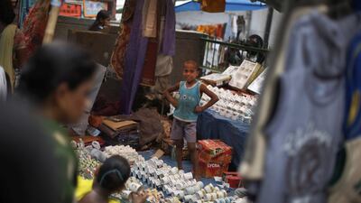 An Indian boy works at a weekly market on the outskirts of New Delhi, India/ Altaf Qadri / AP Photo