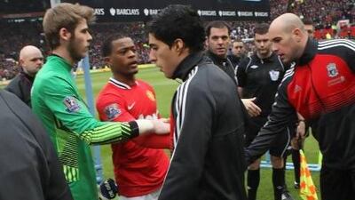 Already facing racism issues, when Luis Suarez, center, refused to shake the hand of Manchester United's Patrice Evra, second from left, the Liverpool striker was followed by a dark cloud the rest of the season.
