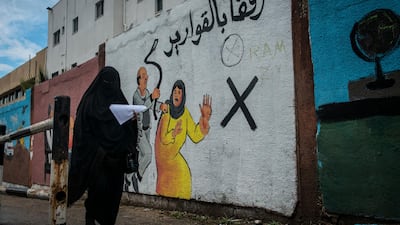 A woman walks by an mural discouraging domestic violence outside if Al-Shifa hospital. According to a 2012 study, some 37% of women are subjected to domestic violence by their husbands.
