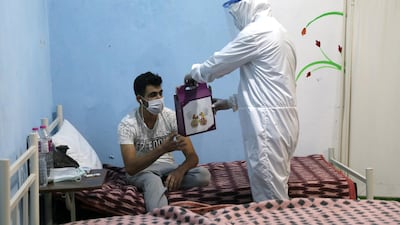 Meals are handed out to a patient at the community treatment centre in Syria's Ariha city. EPA