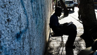 A man reads the Quran as he sits outside the Masjid At-Tawheed mosque in Port-au-Prince, Haiti. AFP