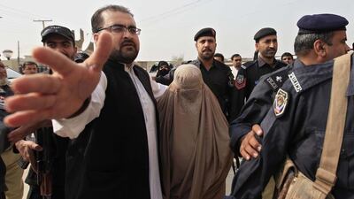 Pakistani security officials escort Sharbat Gula on November 4, 2016, after a court hearing in Peshawar, Pakistan. The so-called ‘Aghan Girl’ was found guilty of illegally obtaining a Pakistani identity card. She was sentenced to jail for 15 days and fined about Dh3,500, and is to be deported to Afghanistan. Bilawal Arbab / EPA