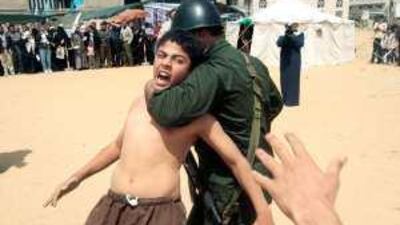 Palestinians enact a scene of an Israeli soldier arresting a Palestinian boy during a rally in Gaza City in solidarity with Palestinian prisoners held in Israeli jails.