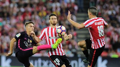 Barcelona midfielder Denis Suarez, left, vies with Athletic Bilbao forward Aritz Aduriz, centre, and midfielder Oscar de Marcos. Ander Gillenea / AFP