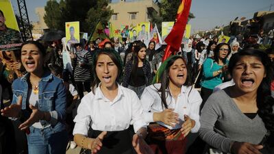 Kurdish and Arab protesters chant slogans against Turkish President Tayip Erdogan as they walk during a march to the United Nations Headquarters in the town of Qamishli, Syria. REUTERS