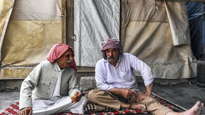 Men sit togther on a futon outside a shelter at a camp for internally displaced persons (IDP) of Iraq's Yazidi minority in the Sharya area, some 15 kilometres from the northern city of Dohuk in the autonomous Iraqi Kurdistan region. AFP