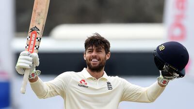 England's Ben Foakes raises his bat and helmet in celebration after scoring a century on debut against Sri Lanka in the first Test in Galle. AFP