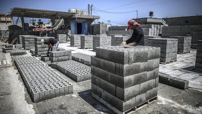 Workers produce construction bricks from the recycled rubble of buildings destroyed during the May rocket attacks. Sanad Latefa for The National