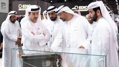 Sheikh Hazza bin Zayed inspects a weapon on the Barij Munition stand.