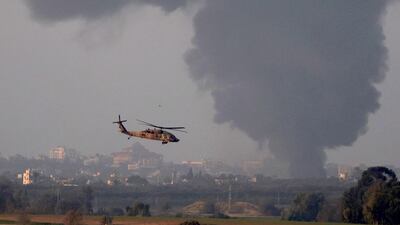 An Israeli army helicopter flies as smoke billows from the Gaza Strip. The war in the Palestinian enclave has had dire economic consequences. EPA