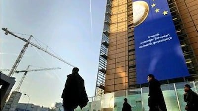 A euro banner promoting stronger European economic governance hangs on the side of the EU headquarters in Brussels.