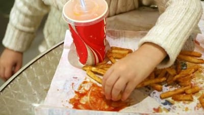 A young boy enjoys food at Abu Dhabi Mall. Experts say people should cut down on such food.